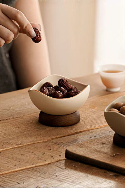 Generic A stylish ceramic serving bowl with a modern design and a wooden base.