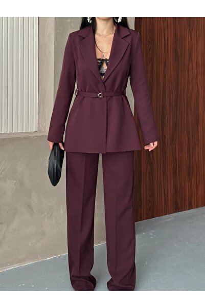 Moda İkra بدلة بليزر مع سترة وبنطلون واسع الساقين، وتُربط عند الخصر بحزام رفيع من نفس اللون.