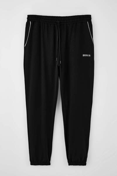 Trendyol Collection Schwarze, bedruckte Jogginghose mit elastischem Beinabsch...