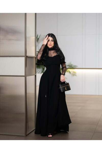 Riva A long, elegant black evening dress. It features a design that combines ...