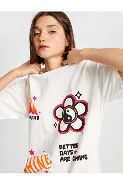 Koton تيشيرت نسائي أبيض برسومات مميزة، مزين باقتباس إيجابي وطبعات جريئة.