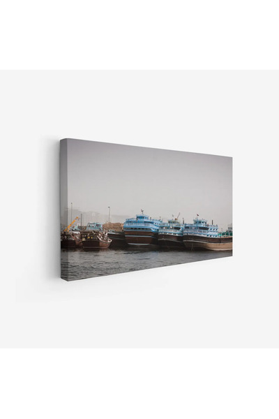 Tajridhome لوحة بحرية لسفن تقليدية بألوان زرقاء وبنية تحت ضباب خفيف، تعكس أجو...