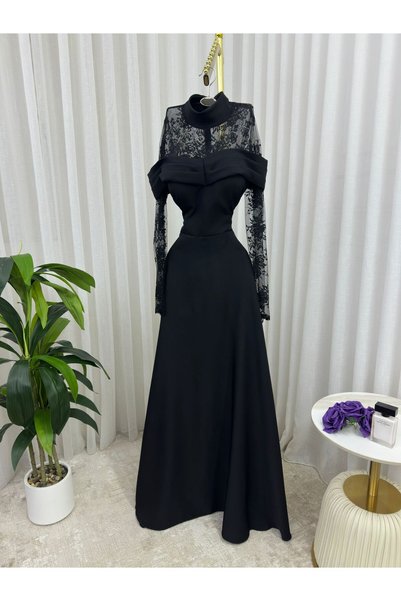 Riva فستان سهرة أسود طويل وراقي. يتميز بتصميم يجمع بين الأناقة الكلاسيكية والعصرية