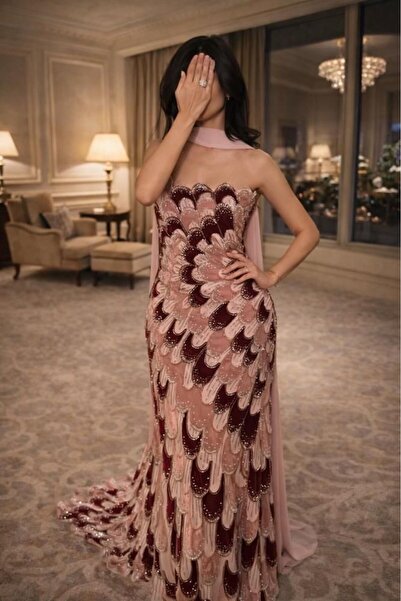 ARENA-SA A pink velvet dress with wavy embellishments and a long train reflec...