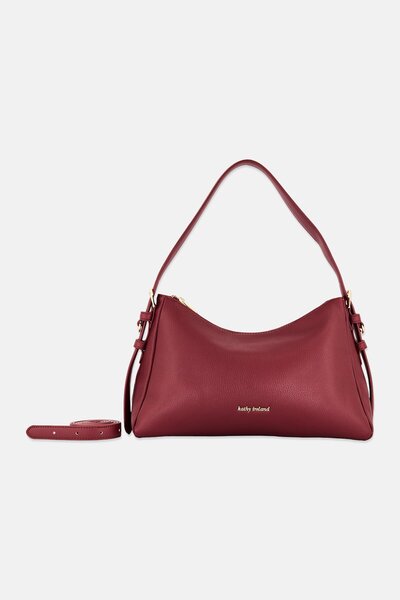 Kathy Ireland حقيبة كتف نسائية بشعار العلامة التجارية، لون عنابي