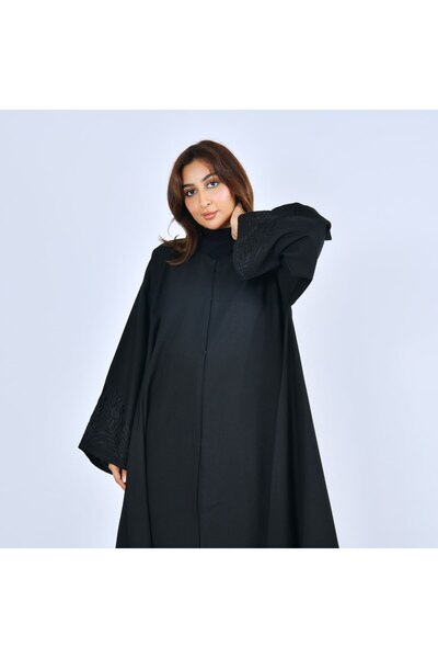 LAMHA A black abaya, closed with snaps, decorated with wheat stalk embroidery.