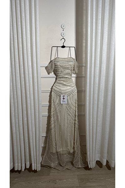 Onila فستان مصنوع من قماش مطرز فاخر مع تافتا ناعم، مما يمنح مظهراً أنيقاً وجذ...