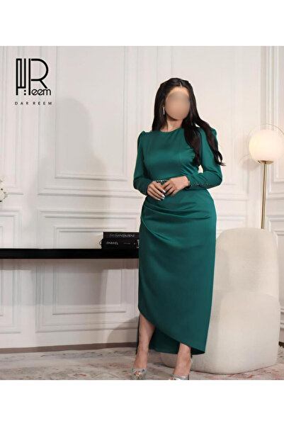 DRM Dar Reem's emerald green evening gown with a fitted waist and luxurious h...