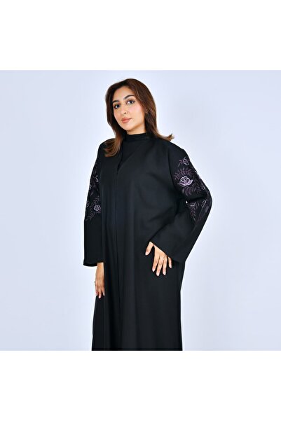 LAMHA A black abaya closed with snaps, decorated with embroidery on the sleeves.
