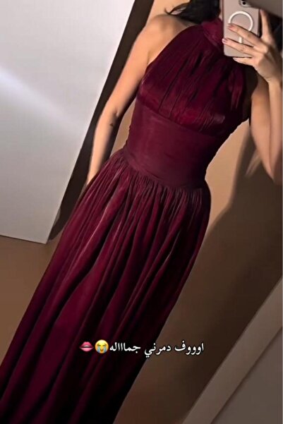 DUBAİ A luxurious burgundy evening gown with an elegant design that highlight...