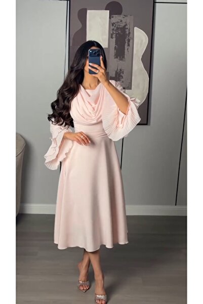 REVE A soft pink dress, featuring a draped collar and elegant ruffled sleeves.