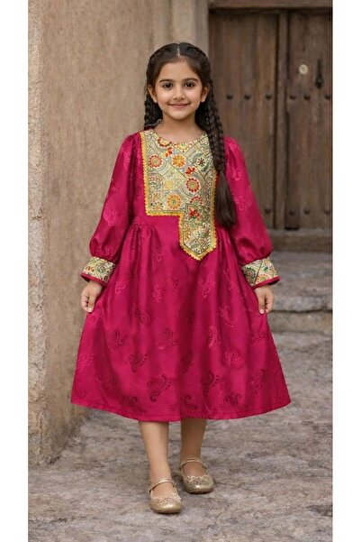 La reina petite A soft, folk-style dress in fuchsia with a pattern and embell...
