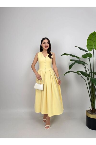 Miss Janell A soft and elegant yellow sleeveless dress adorned with dangling ...