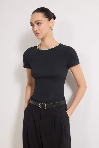 ترينديول كوليكشن بلوزة سوداء مطاطية محبوكة بأكمام قصيرة وتفاصيل إكسسوارات قما...