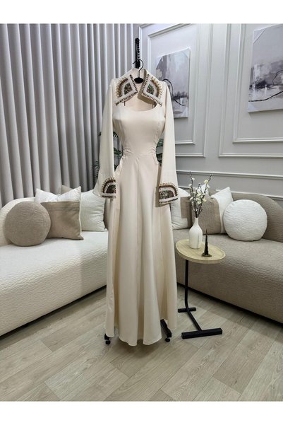 Dubai Elegant long dress in a soft off-white color, with a sophisticated design that combines simplicity and luxury.