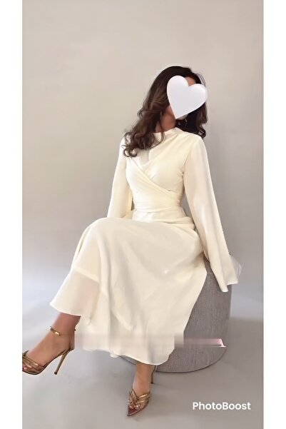 REVE A long, soft white dress with wide sleeves and a crisscross design at th...