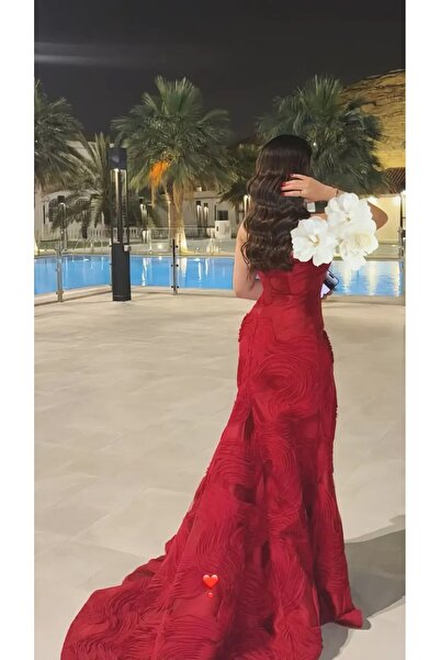 Azyaa Al-Amira A luxurious red evening gown in a fitted "Rosetta" design with...