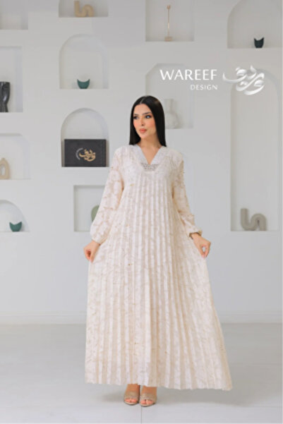 WAREEF FASHION A cream-colored jalabiya with delicate pearl embroidery and el...