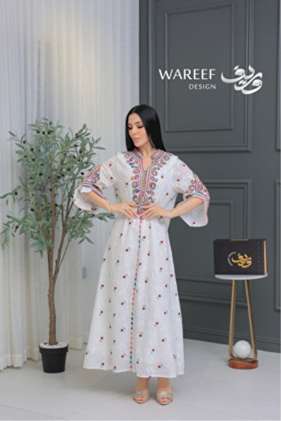 WABISABIDECORATION A white jalabiya embroidered with colorful traditional pat...