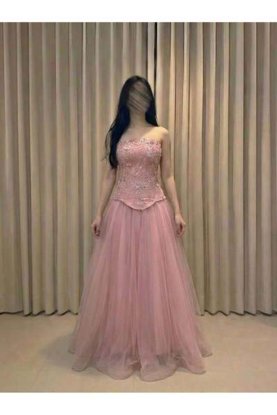 DUBAİ An elegant evening dress in a soft pink hue, featuring an off-the-shoul...