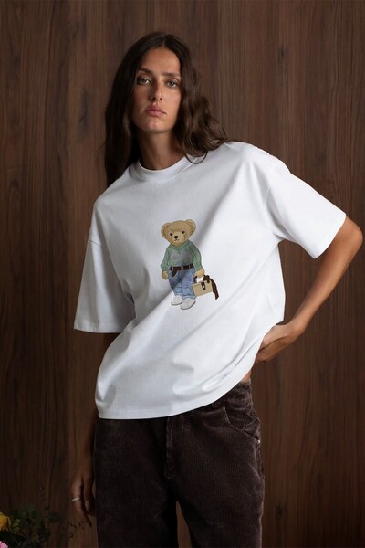 The Champ Clothing تي شيرت نسائي كبير الحجم مطبوع عليه COZY Bear باللون الأبي...