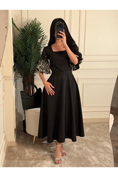 ELEEN EST A black midi dress with an elegant, feminine cut and embroidered sl...