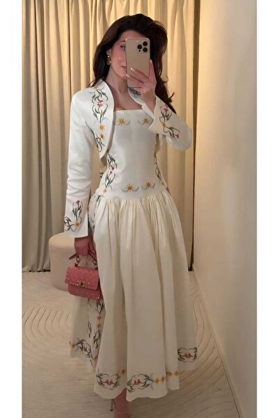 Mara A soft white dress with an elegant, feminine design.