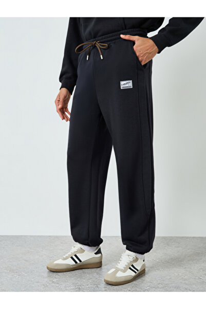 Styli Men Black Elastic Hem Relaxed Badge Joggers