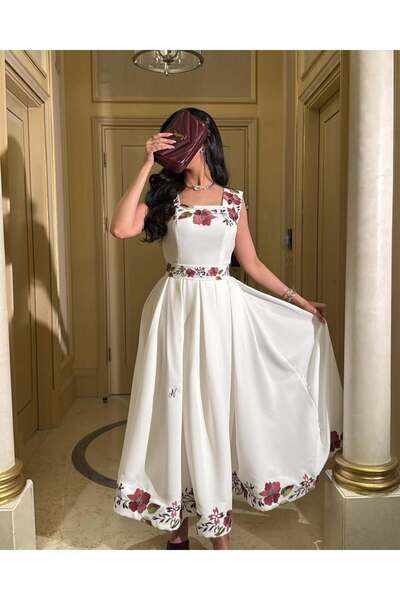 FASHION فستان أبيض ناعم مزين بنقوش وردية حمراء على الصدر والخصر والأطراف.