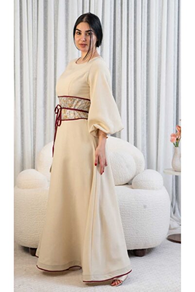 DVNA Asala's dress is beige with puffed sleeves and a belt embroidered with b...