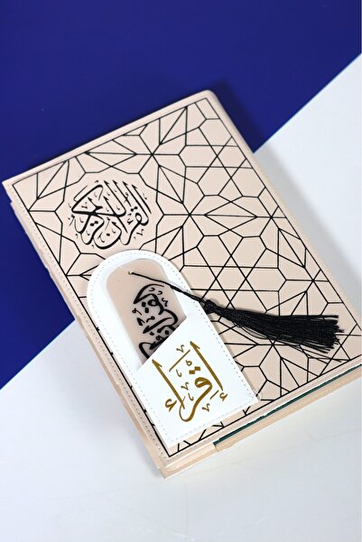 casing A light beige Quran decorated with black geometric patterns, with a wh...