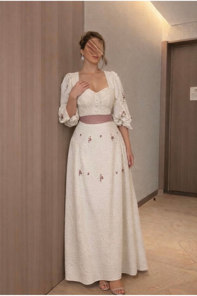 Joji A long, elegant off-white dress with a soft, feminine design that elegan...