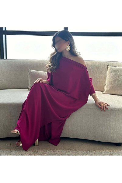 REVE A modern fuchsia jalabiya with an exposed shoulder, decorated with fabri...