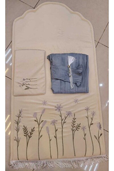 RUG A cream-colored prayer rug with bluish-gray embroidery, along with a care...