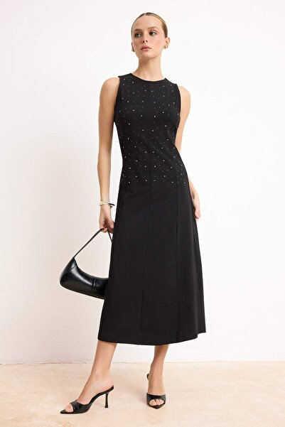 ترينديول كوليكشن فستان أسود بقصة A/شكل جرسي بدون أكمام مع تفاصيل إكسسوارات، ف...