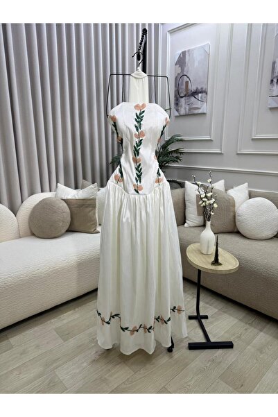 FASHION A long white dress, decorated with green floral embroidery and delica...