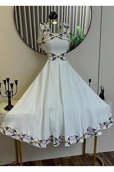 alweshah alahmar A white dress with colorful floral embroidery and a wide skirt.