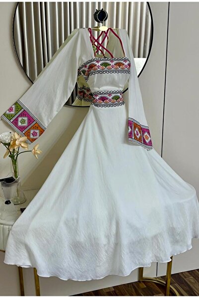 alweshah alahmar A white dress with colorful embroidery and a touch of heritage.