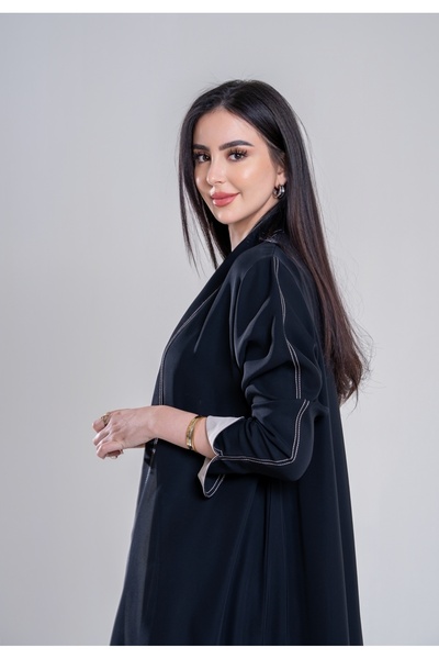 Al Afnan Boutique An abaya made of deep black crepe fabric with an elegant, s...