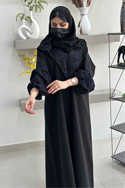 Hasnaa Abaya An abaya with an elegant collar, gathered sleeves, and navy blue...
