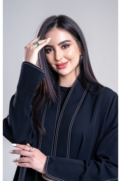 Al Afnan Boutique An abaya made of deep black crepe fabric with an elegant, s...