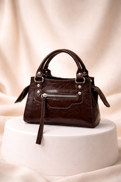 Miernebag حقيبة كروس نسائية من ريفير بتفاصيل مزينة بقلادة معلقة باللون البني