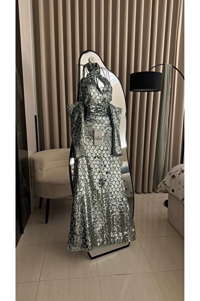 Nareen Fashion فستان سهرة فاخر بلون فضي لامع، مصمم بقصة طويلة انسيابية تبرز ج...