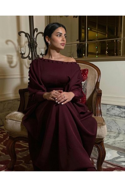 Ayaen جلابية أنيقة، منسدلة، بكتف مكشوف وتفاصيل أزرار مميزة.