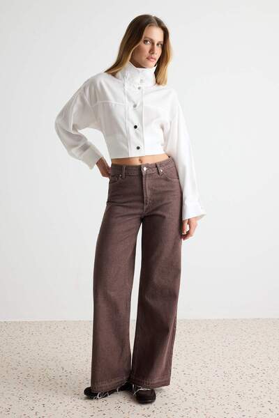 Trendyol Collection بنطلون جينز بني عتيق الطراز بتفاصيل مغسولة عند الأرجل وخص...