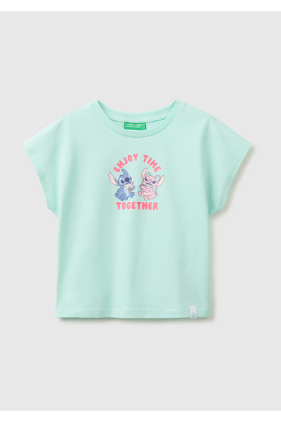 United Colors of Benetton تي شيرت للفتيات ذو ياقة دائرية وطباعة ليلو وستيتش ب...