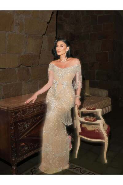 FASHION فستان سهرة بيج مطرز بالكامل بكريستال لامع وشراريب انسيابية مع فيونكات...