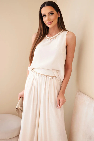 Kesi Set elegant bej: top fără mâneci și pantaloni largi, cu detalii decorative.
