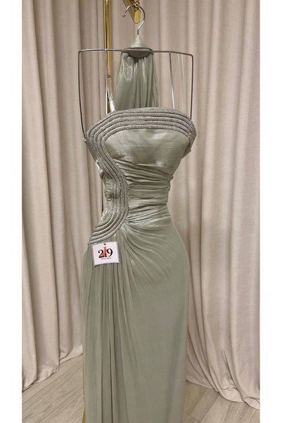 Boutique 219 فستان سهرة طويل بلون زيتي فاتح حريري بتصميم درابيه يربط حول الرقبة مع تطريز جانبي أنيق.