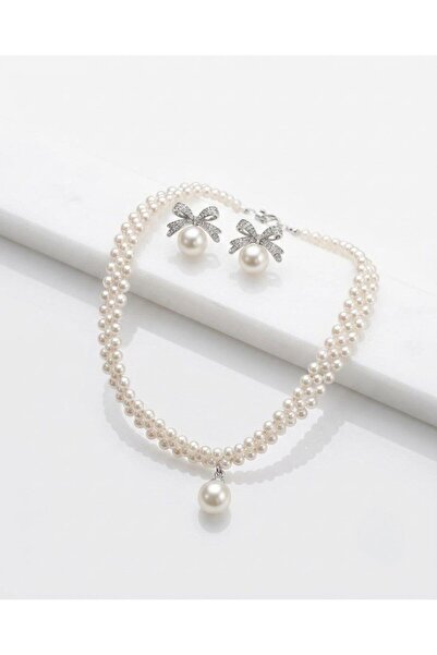 Nevara Elegant Set Featuring a Multi-Row Pearl Necklace, a Dangling Pearl Pendant, and Crystal-Studded Bow Earrings, Offering a High-End and Classic Look Suitable for Various Occasions.